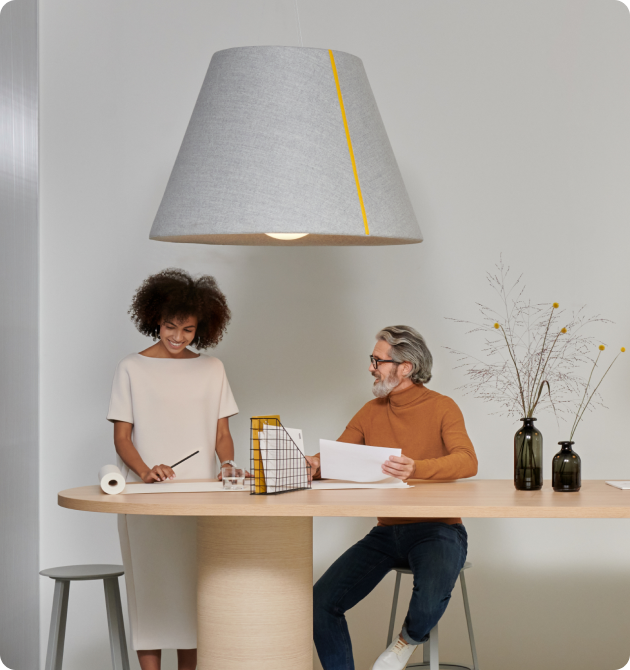 Mute Bell Lamp in office interior with tabletop beneath and people talking