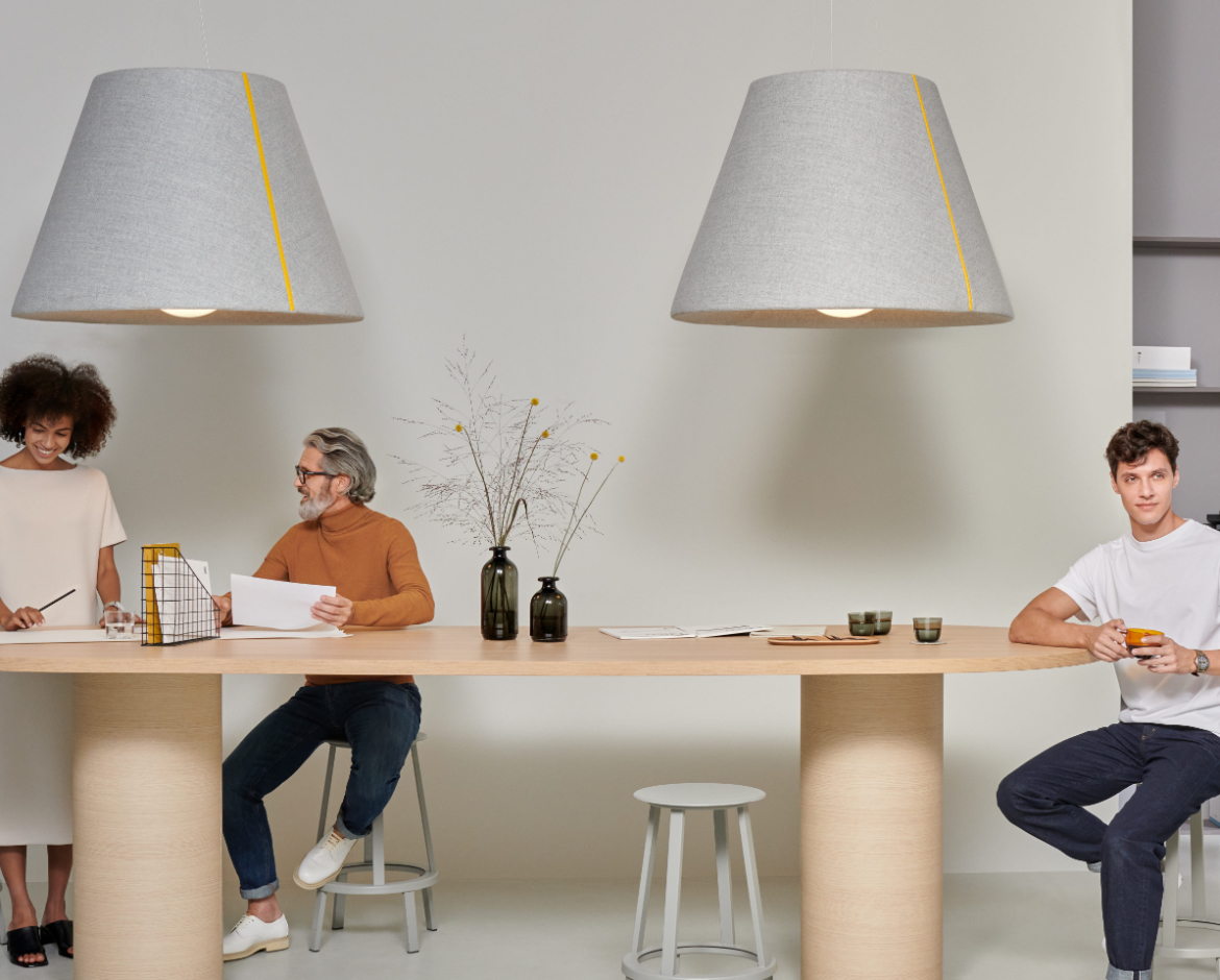 Mute Bell Lamp in office interior with tabletop beneath and people talking