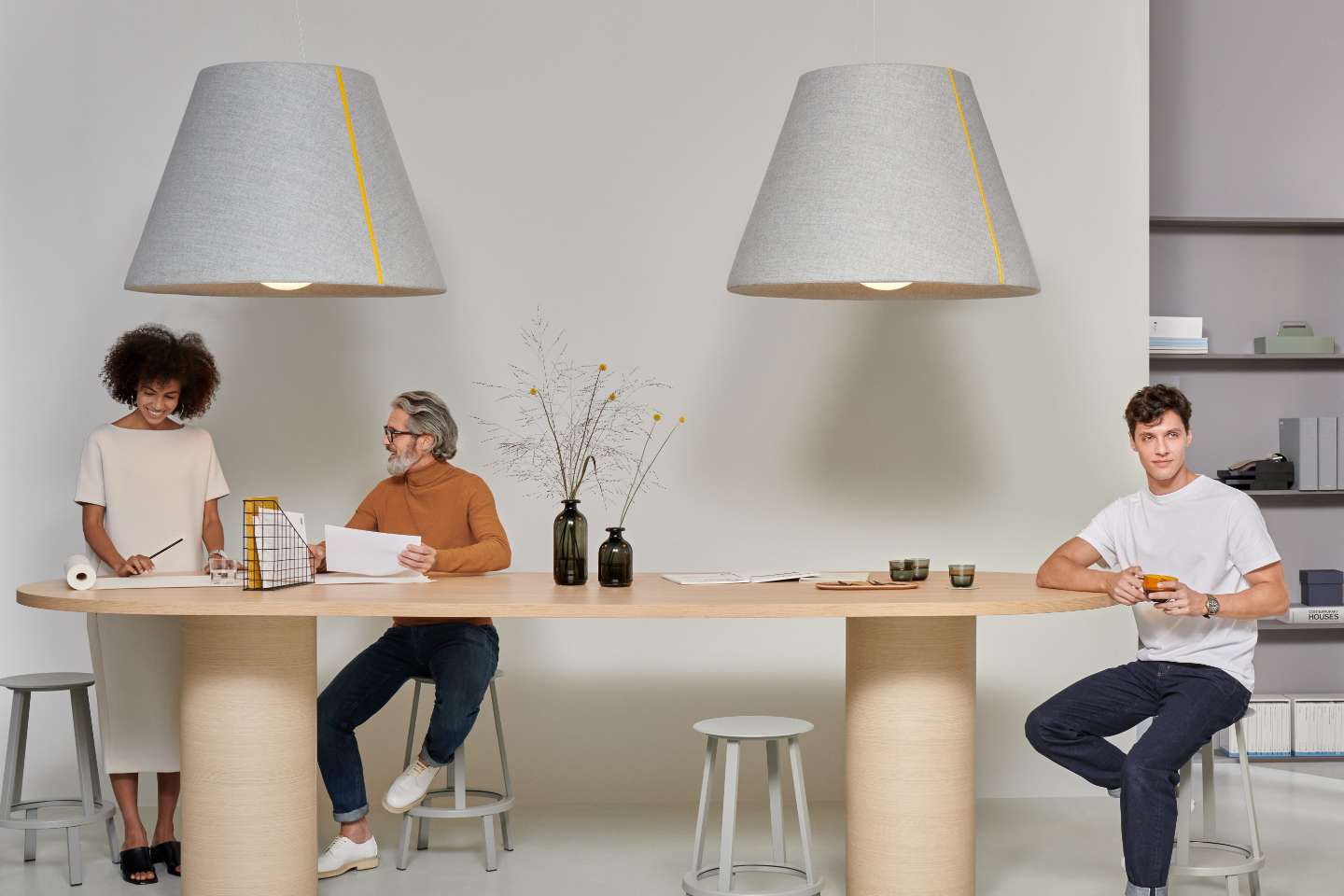 Mute Bell Lamp in office interior with tabletop beneath and people talking
